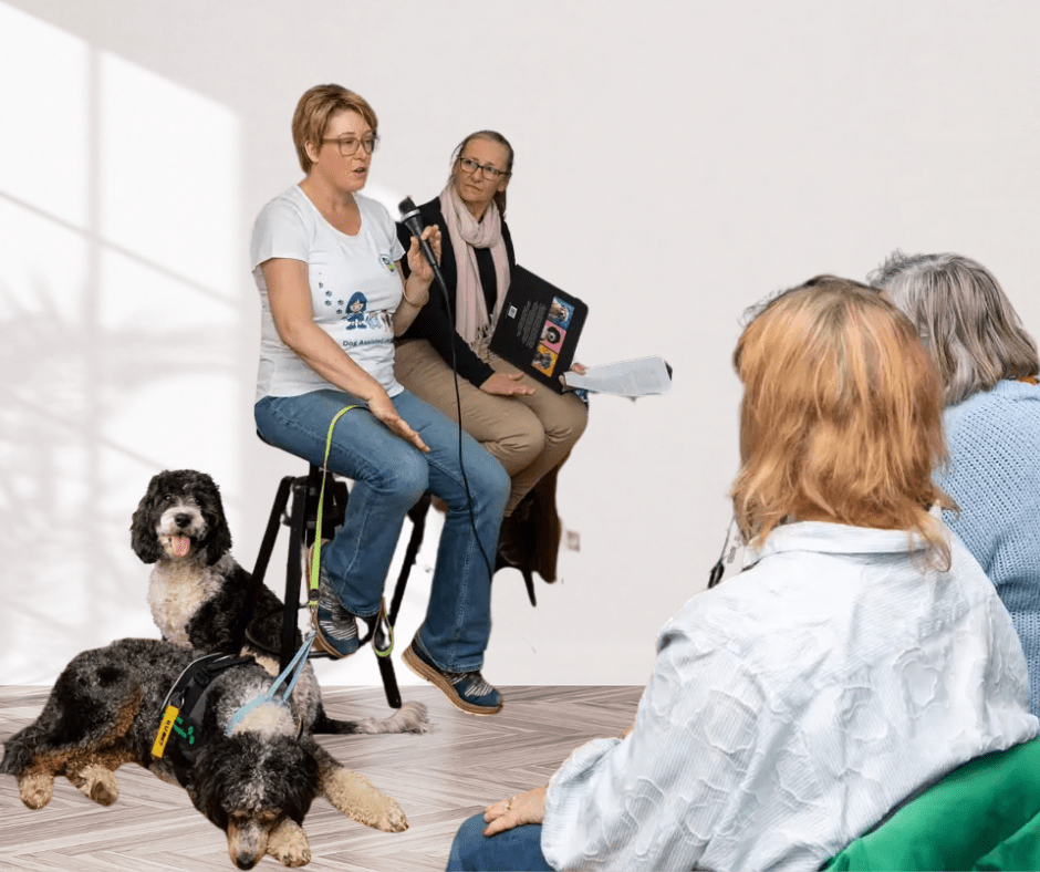Sarah speaking event holding mic Canine Comprehension with therapy dogs Gruffalo and Maisey